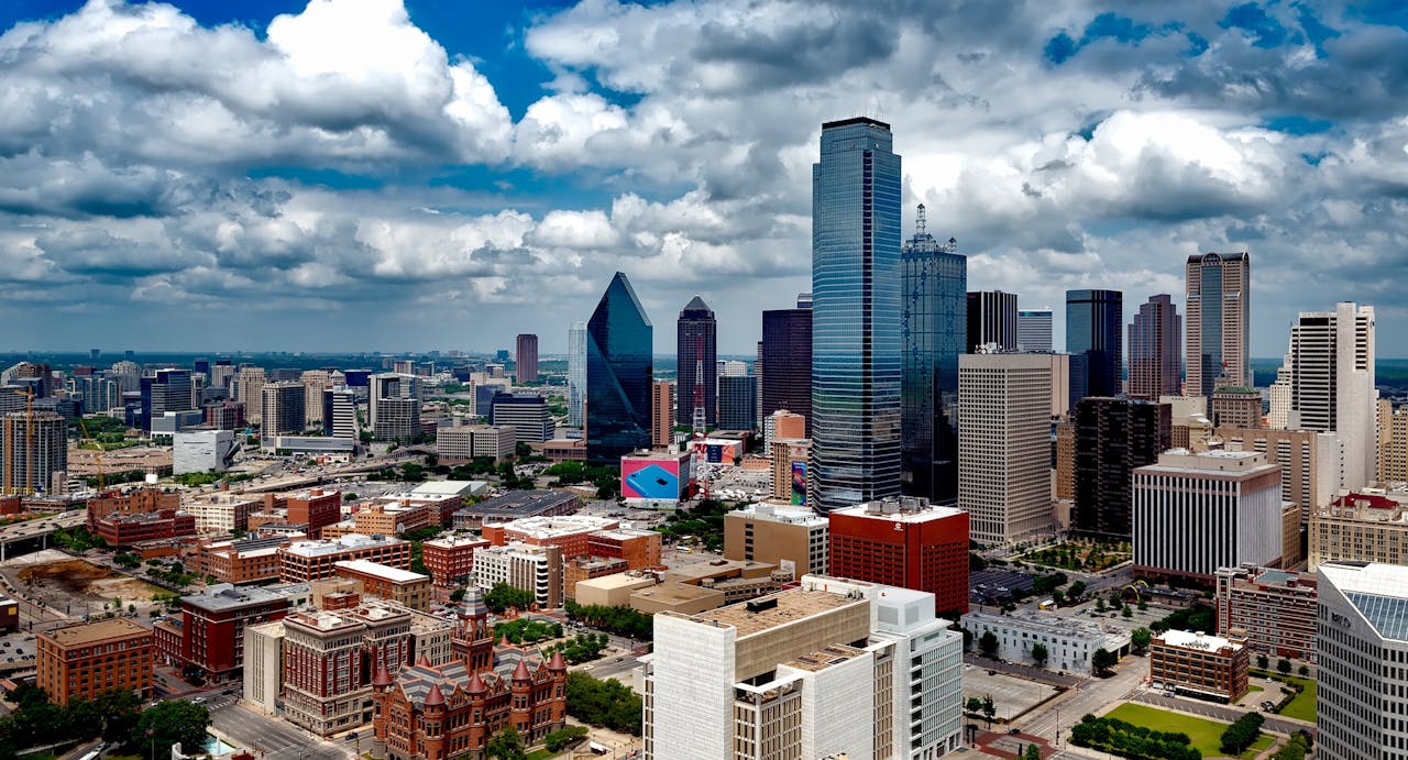 A stunning panoramic view of the Dallas skyline under dramatic clouds, capturing the citys iconic skyscrapers.